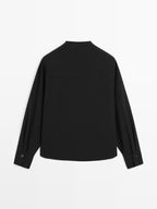 Blouse with crossover detail and button